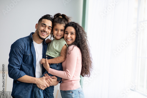 Portraif Of Happy Arabic Parents Posing With Their Little Daughter At Home photo