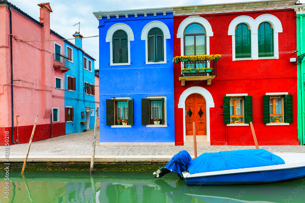 Colorful houses on the canal in Burano island, Venice, Italy. Famous travel destination.