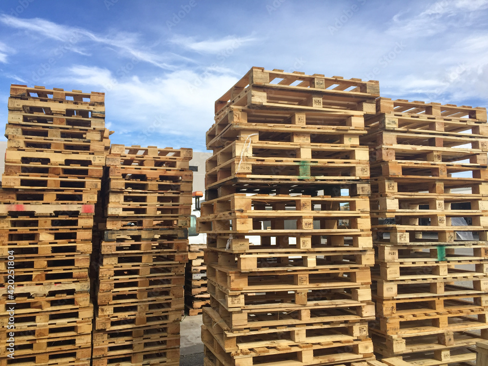Wooden pallets stacked against blue sky