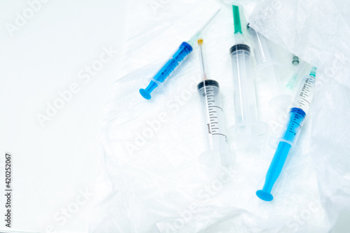 Several disposable syringes of different sizes close-up on a white surface. Selective focus. Medical equipment for intravenous and intramuscular injection of medicinal solutions.