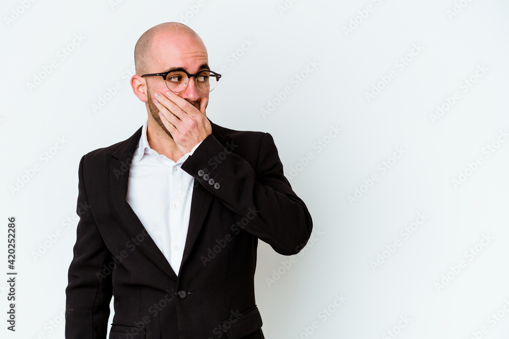 Young business caucasian bald man isolated on blue background thoughtful looking to a copy space covering mouth with hand. Young business caucasian bald man isolated on blue background thoughtful looking to a copy space covering mouth with hand.