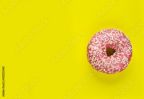 Donut with icing on pink background.