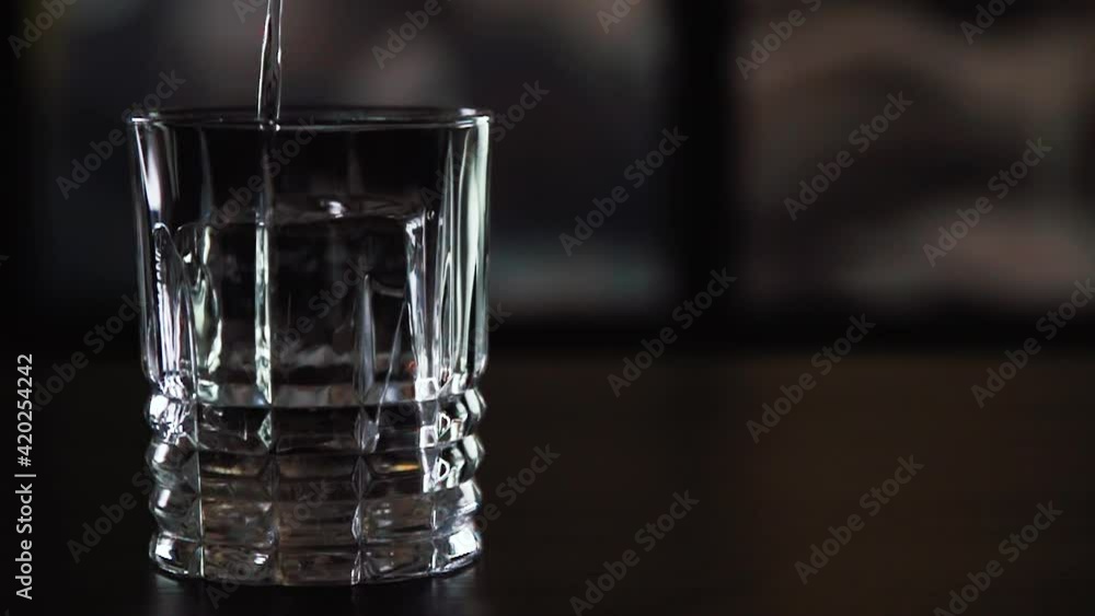 The glass is filled with a cocktail in general. A clear liquid is poured into the glass The glass is filled with a cocktail in general. A clear liquid is poured into the glass