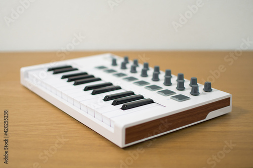 White midi keyboard with knobs and pads photo