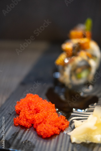 Tobiko flying fish roe served on side dish in sushi tray.