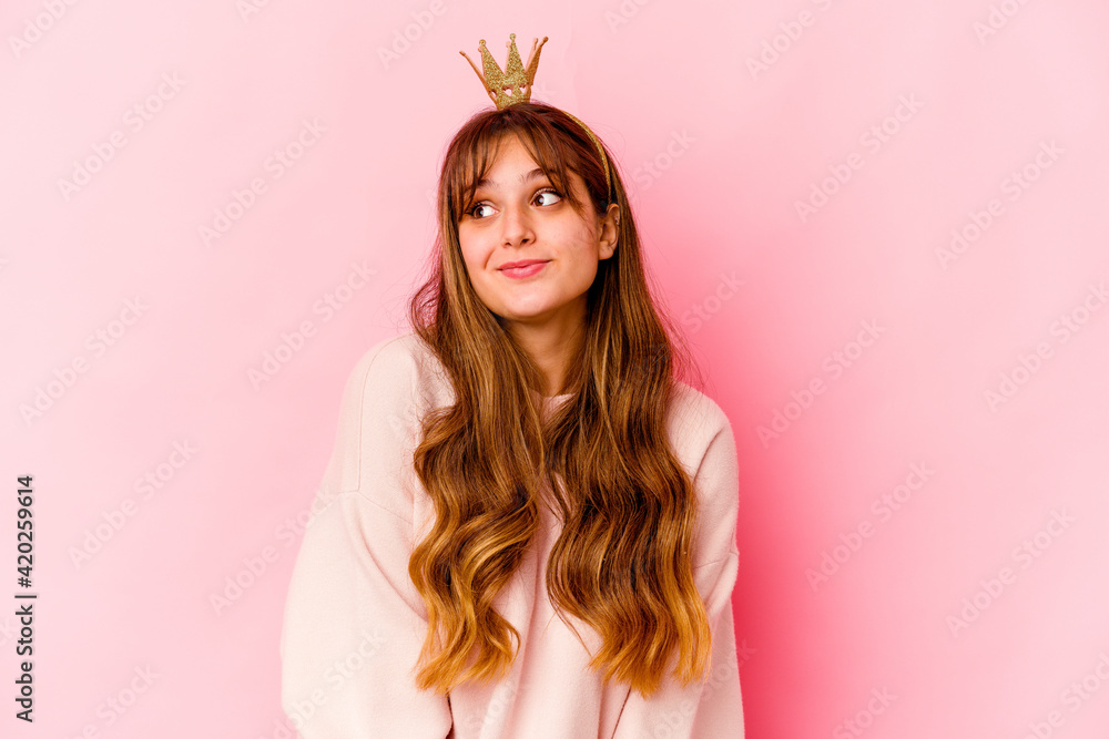 Young caucasian woman with princess crown isolated dreaming of achieving goals and purposes Young caucasian woman with princess crown isolated dreaming of achieving goals and purposes