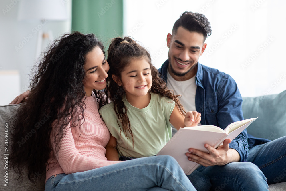 Happy Middle-Eastern Family With Little Daughter Reading Book Together Happy Middle-Eastern Family With Little Daughter Reading Book Together