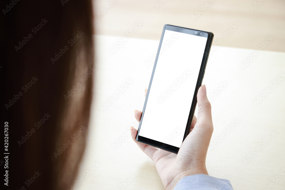 A woman holding a black smartphone with a white screen Connect with online technology communications. Smartphone concept with screen, free space for copying text or information content. Clipping Path