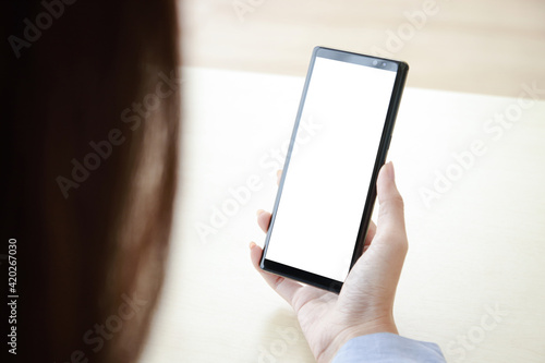 A woman holding a black smartphone with a white screen Connect with online technology communications. Smartphone concept with screen, free space for copying text or information content. Clipping Path