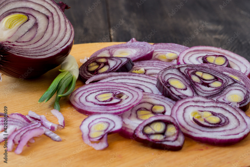 Tropea onion cut into slices on a cutting board.