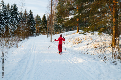 Small child in the ski track at winter forest in Finland.