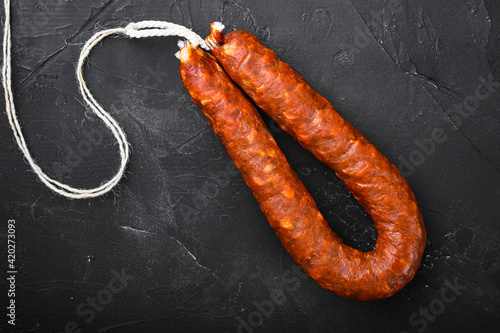 Spanish pork chorizo sausages on black textured background