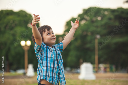 happy boy with outstretched hands to the sky in the park © Andriy Petrenko