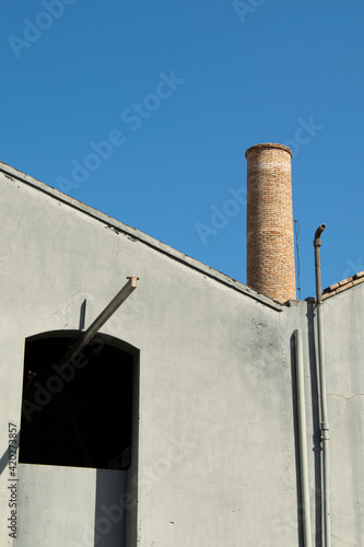 Chimenea industrial que sobresale sobre las paredes de una construcción.