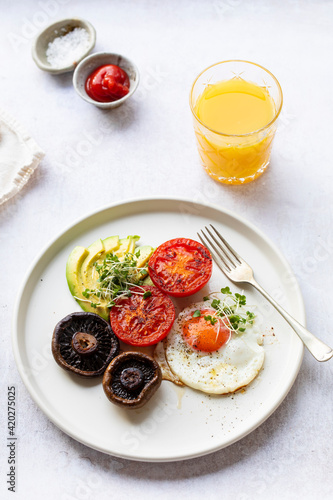 Vegetarian breakfast with fried egg, tomatoes, mushroom and avocado