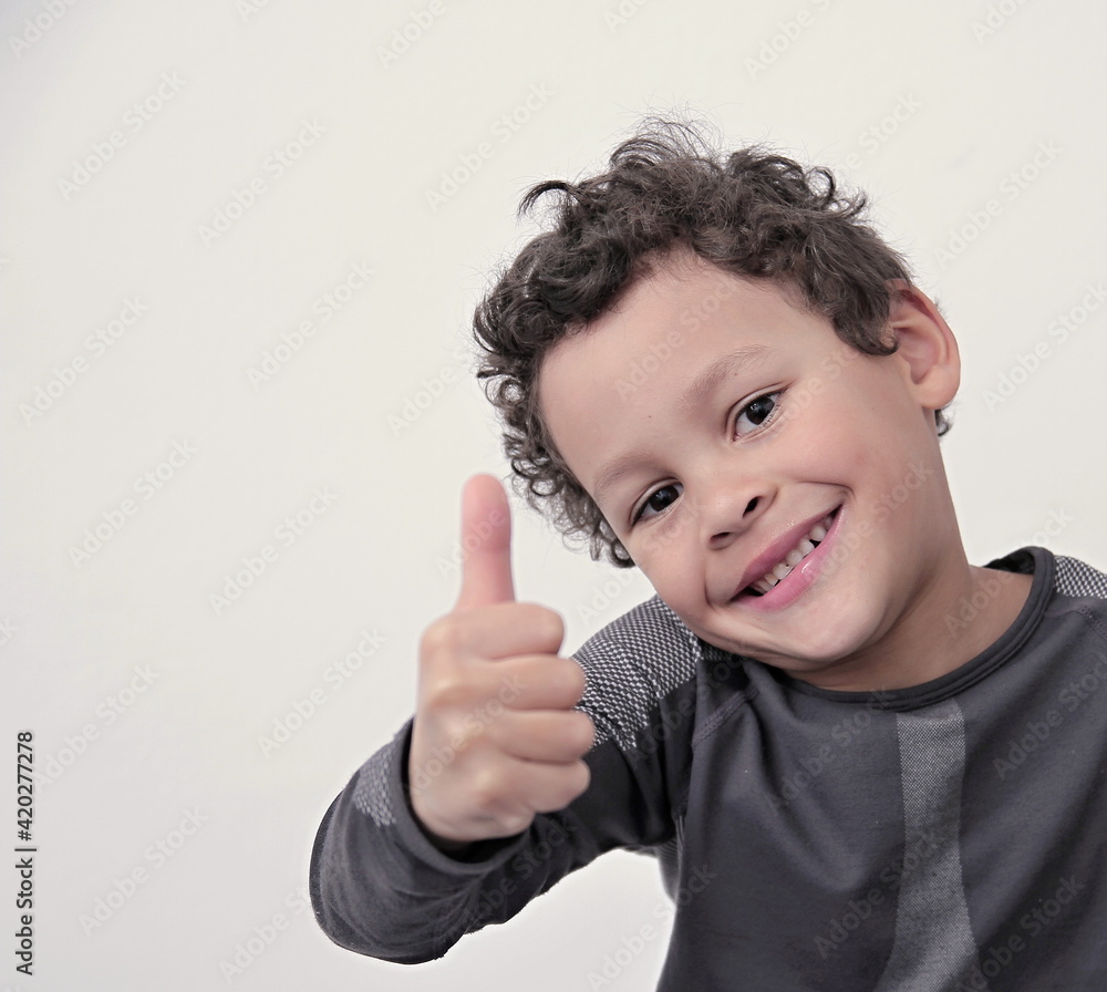 boy showing thumbs up gesture on white grey background stock photo boy showing thumbs up gesture on white grey background stock photo