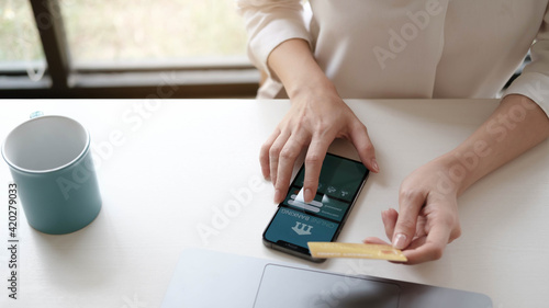 woman in casual shirt paying with credit card online while making orders via the Internet. Successful black businesswoman making transaction using mobile bank application.