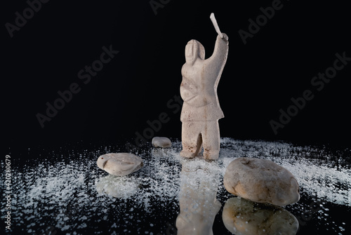 Obraz na płótnie Small statue of Inuit hunter with a spear made of animal bone