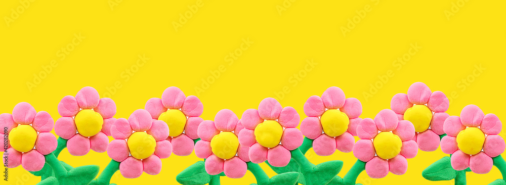 Many plasticine flowers on a yellow background Many plasticine flowers on a yellow background