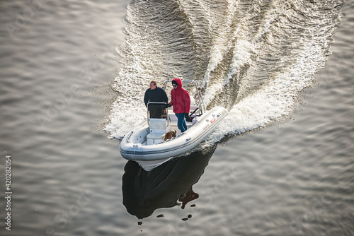 Prague, Czech republic - February 24, 2021. Speed white dinghy boat with two man on board in Winter photo