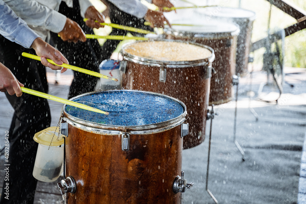 Drums stand in a row. drumsticks. drummers. splashes of water on the membrane Drums stand in a row. drumsticks. drummers. splashes of water on the membrane