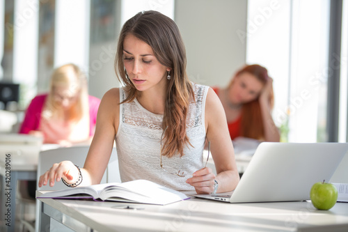 Free Download Pretty young college student in a library (shallow DOF; color toned image) - GFXLoad