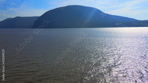 Aerial drone footage of the Appalachian mountains over a river valley in new york in the hudson river valley looking at storm king mountain in early spring photo