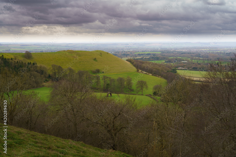 Obraz premium scenic Southerly view over Oare and across the Pewsey Vale valley with green pastures and a moody raincloud sky