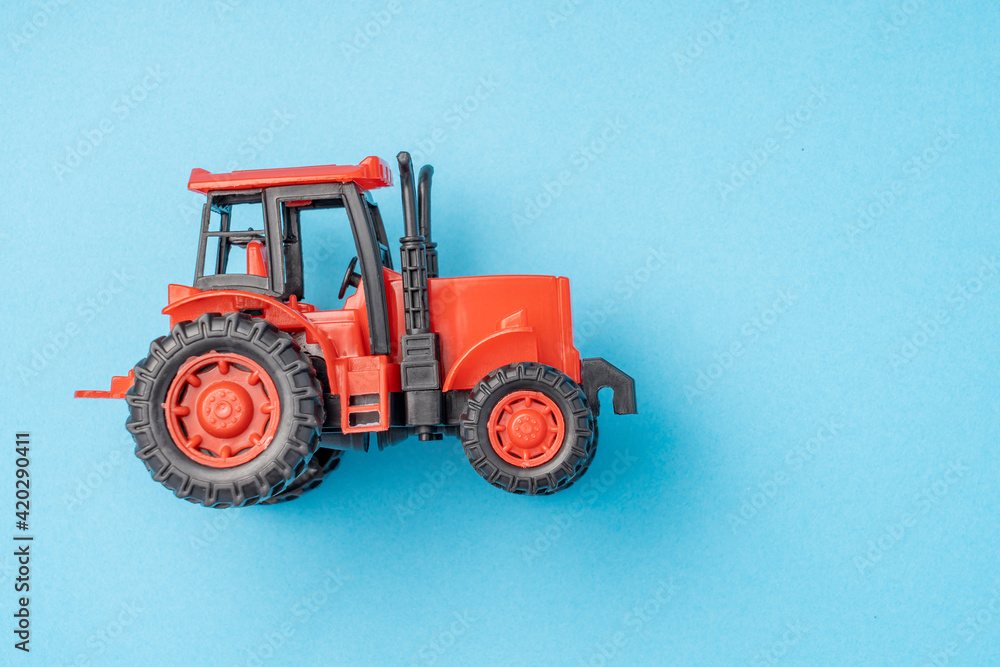 red toy tractor on a blue background, banner. red toy tractor on a blue background, banner.