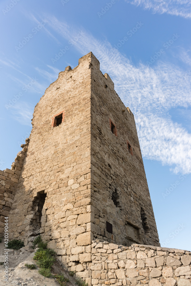 Bottom-up view of the stone wall of the Clement defensive tower the medieval fortress of Kafa. Blue sky