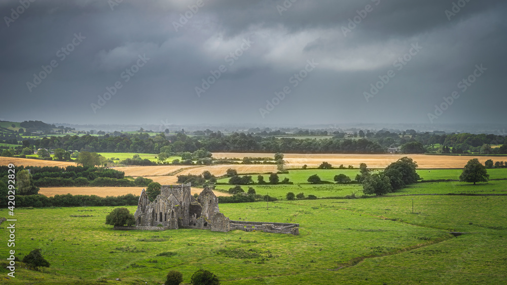 Old ruins of Hore Abbey surrounded by fields and forest, dark dramatic storm sky. Located next to Rock of Cashel castle, County Tipperary, Ireland Old ruins of Hore Abbey surrounded by fields and forest, dark dramatic storm sky. Located next to Rock of Cashel castle, County Tipperary, Ireland
