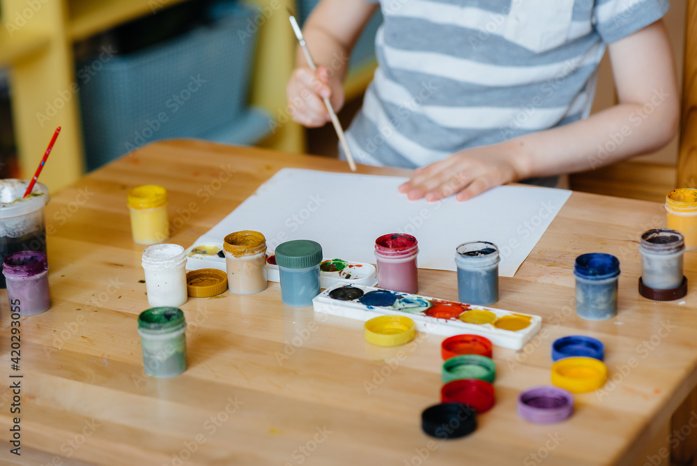 A cute little boy is playing and painting in his room. Recreation and entertainment. Stay at home A cute little boy is playing and painting in his room. Recreation and entertainment. Stay at home