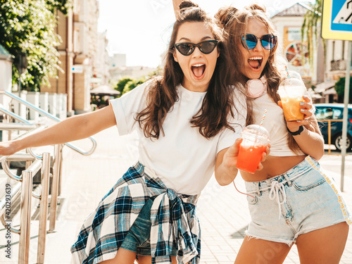 Canvas Print Two young beautiful smiling hipster female in trendy summer clothes