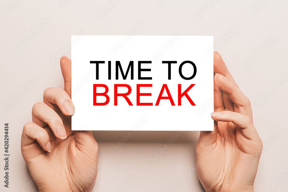 Female hands hold card paper with text TIME TO BREAK on a yellow background. Business and finance concept Female hands hold card paper with text TIME TO BREAK on a yellow background. Business and finance concept