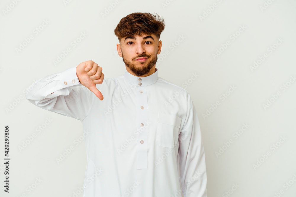 Young Moroccan man wearing a typical arab clothes isolated on white background showing a dislike gesture, thumbs down. Disagreement concept. Young Moroccan man wearing a typical arab clothes isolated on white background showing a dislike gesture, thumbs down. Disagreement concept.