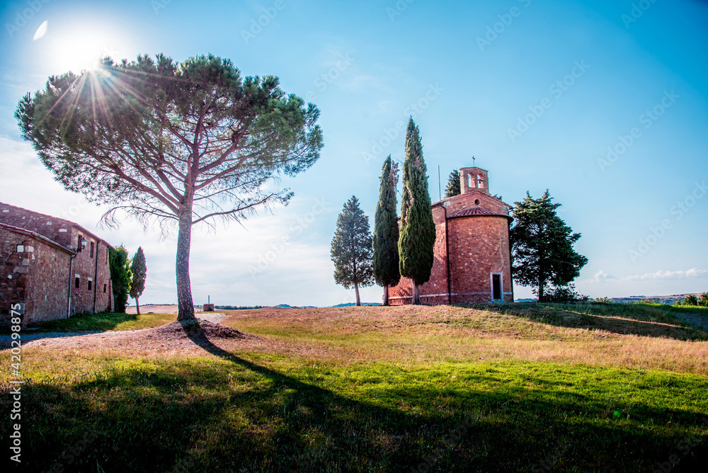Magic landscape with chapel of Madonna di Vitaleta on a sunny day in San Quirico d'Orcia (Val d'Orcia) in Tuscany, Italy. Excellent tourist places.