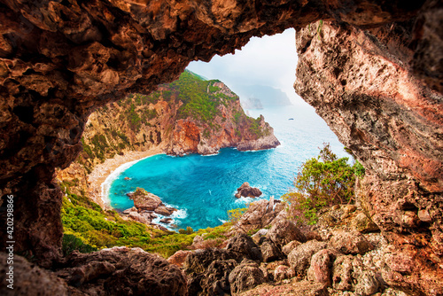 Beautiful magical view of the Gyali beach in Corfu, Greece through a hole in the rock. amazing places. popular tourist atraction. © anko_ter