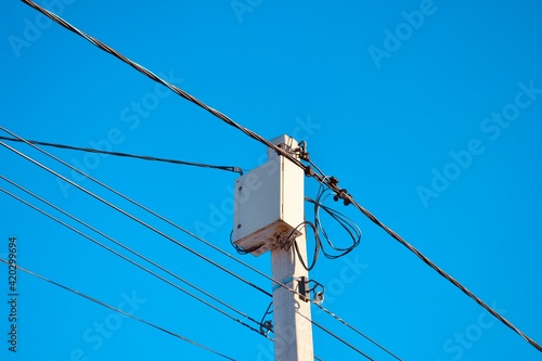 telephone pole tower with wires cables on the blue sky background 