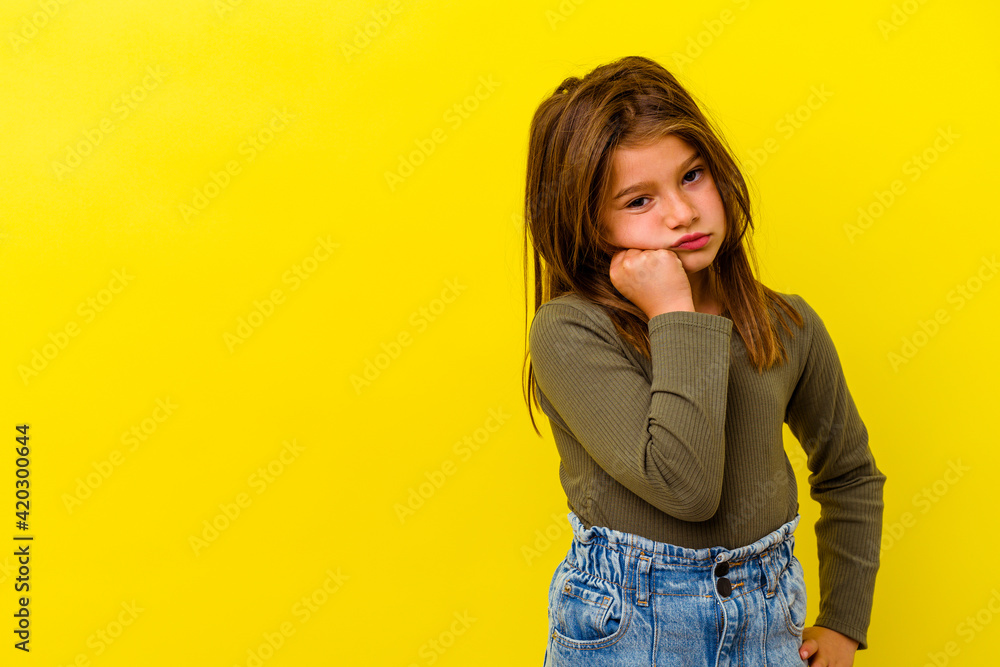 Little caucasian girl isolated on yellow background who feels sad and pensive, looking at copy space. Little caucasian girl isolated on yellow background who feels sad and pensive, looking at copy space.