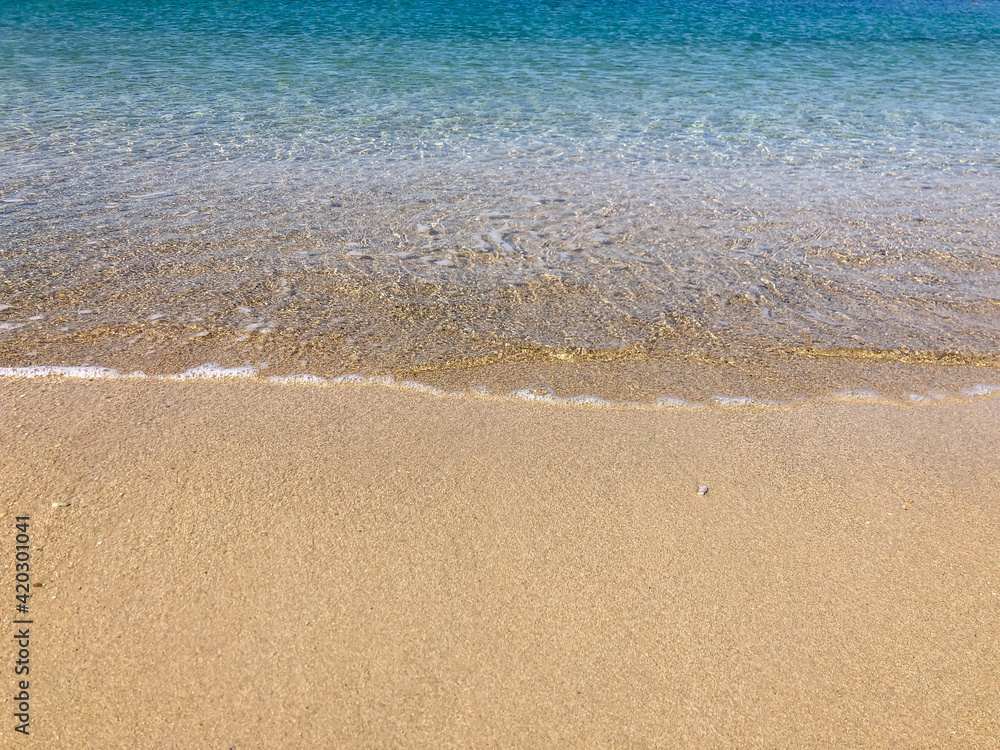 smooth waves of the sea on a sandy beach in summer