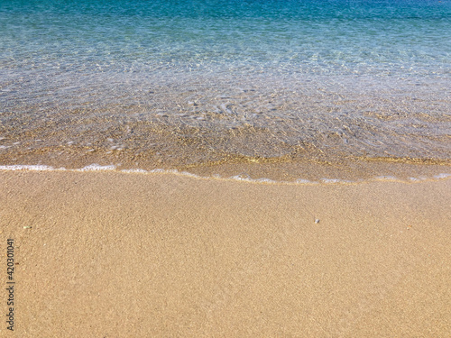 smooth waves of the sea on a sandy beach in summer