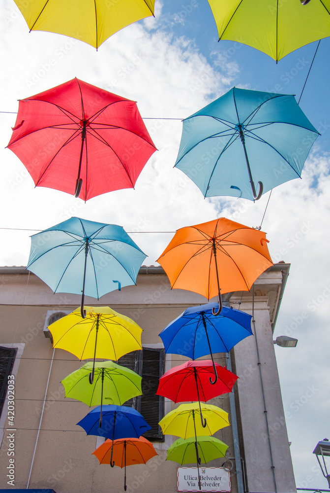 Fototapeta premium Two rows of colourful umbrellas on the sky