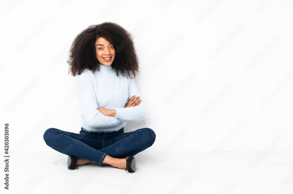 Young african american woman sitting on the floor with arms crossed and looking forward Young african american woman sitting on the floor with arms crossed and looking forward