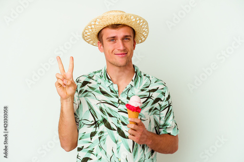 Young caucasian man wearing a summer clothes and holding a ice cream isolated on white background