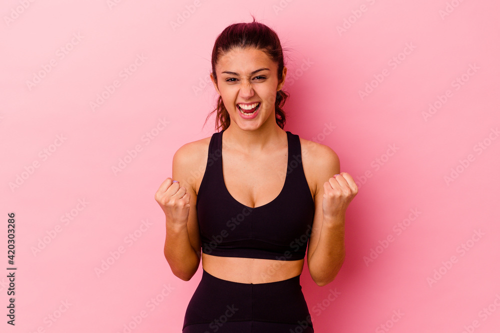Young sport Indian woman isolated on pink background cheering carefree and excited. Victory concept. Young sport Indian woman isolated on pink background cheering carefree and excited. Victory concept.