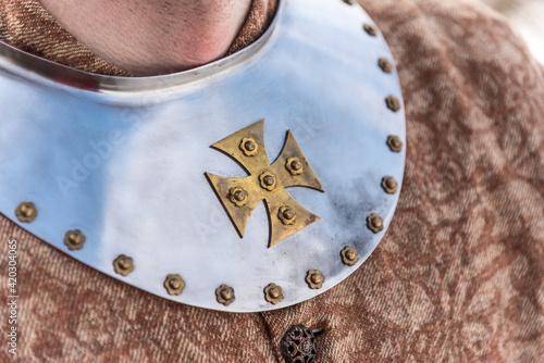 Cross on the metal piece of medieval clothing photo