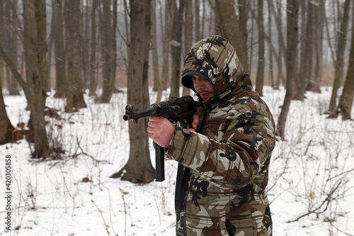 The soldier with old german machine gun in the snowy forest