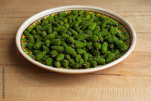 Many green pine cones on the ceramic plate