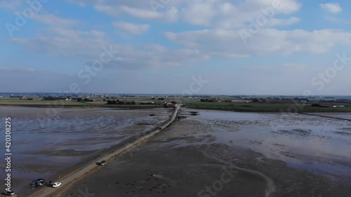 view of car crossing The passage du Gois, Noirmoutier island. France. Aerial view of Noimoutier submergible road (Gois).  photo