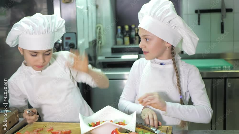 Healthy eating. Children cutting vegetable salad in the restaurant kitchen Healthy eating. Children cutting vegetable salad in the restaurant kitchen